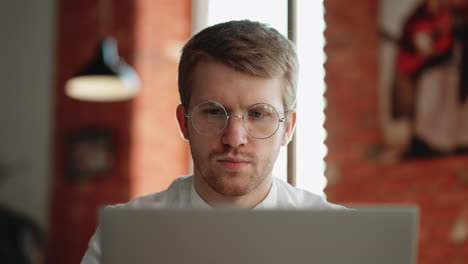adult-man-is-reading-news-in-internet-by-laptop-sitting-in-cafe-in-daytime-portrait-of-pensive-concentrated-man-with-glasses
